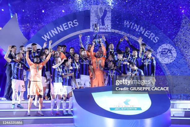 Inter Milan's players lift the trophy to celebrate winning the Italian SuperCup football match between AC Milan and Inter Milan, at the King Fahd...