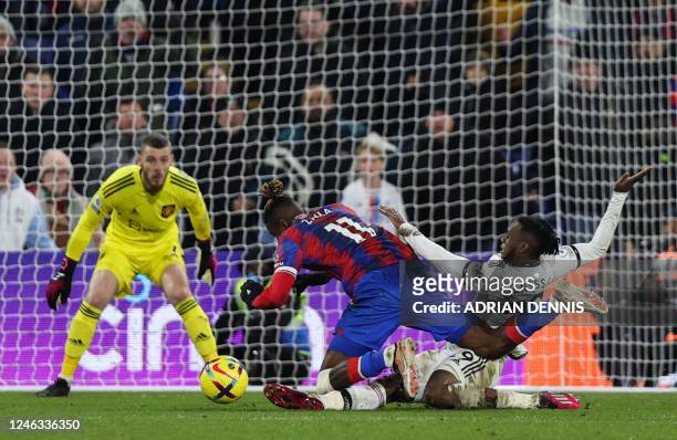 Manchester United's English defender Aaron Wan-Bissaka tackles Crystal Palace's Ivorian striker Wilfried Zaha as he runs with the ball towards the...