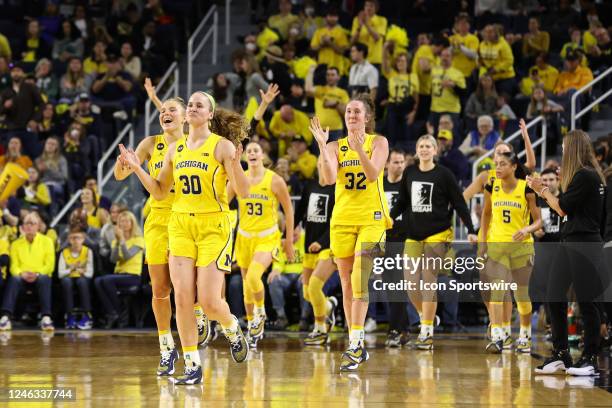 Michigan Wolverines guard Elise Stuck and Michigan Wolverines guard Leigha Brown along with their teammates run onto the court to celebrate after...