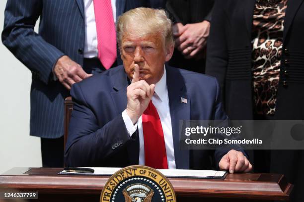 President Donald Trump shushes journalists before signing the Paycheck Protection Program Flexibility Act in the Rose Garden at the White House June...