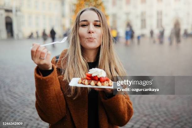frau isst belgien waffeln - waffel kuchen und süßwaren stock-fotos und bilder