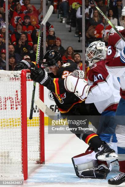 Michael Stone of the Calgary Flames crashes the net against Alexandar Georgiev of the Colorado Avalanche at Scotiabank Saddledome on January 18, 2023...