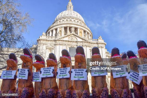 Activists wearing dinosaur costumes hold placards which state 'Eating meat is primitive' and 'It's 2023, time to evolve' during the demonstration...