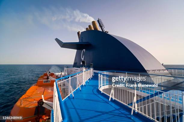 An orange lifeboat attached to the upper deck of the ferry Cruise Ausonia on its way from Livorno to Palermo.