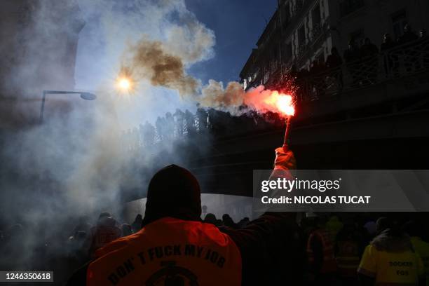 Protester waves a light flare during a rally called by French trade unions against the government pension reform plan in Marseille, southern France,...