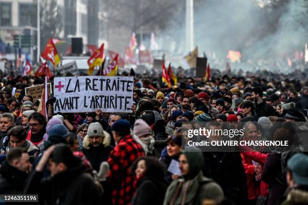 Protestor holds a placard which reads as 'retirement before arthritis' during a rally in Lyon, south-eastern France on January 19 as workers go on...