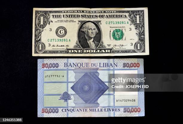 This picture shows a one US dollar bill above a fifty thousand Lebanese pound banknote, in the Lebanese capital Beirut, on January 19, 2023. - The...