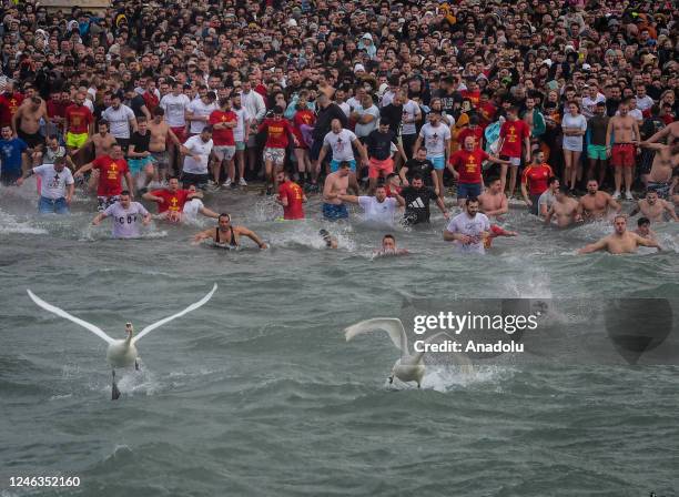 Hundreds of Christian Orthodox believers swim for a crucifix, casted by Macedonian Orthodox Bishop Timotej, in to the freezing water of Lake Ohrid,...