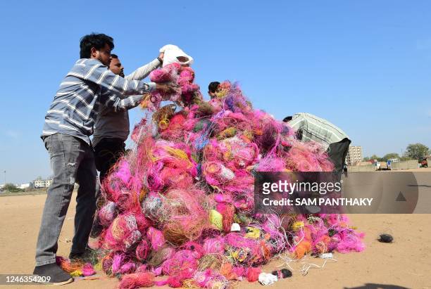 Volunteers stack strings used for kite flying, to burn as a mark of protest in order to prevent injuries caused by strings to birds and people on the...