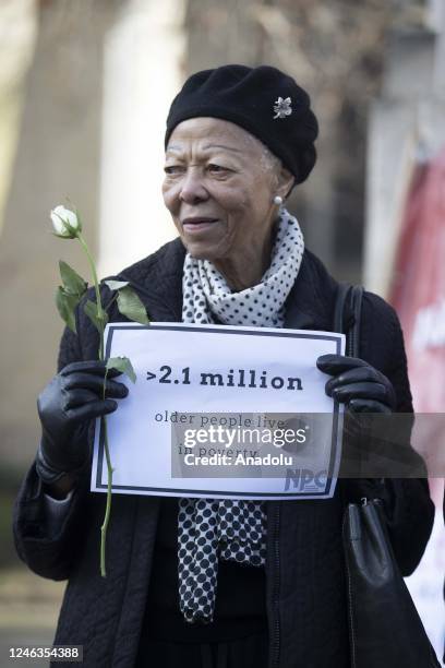 Woman holds a banner as people gather for a demonstration in Downing Street, where the Prime Minister's Office is located, to protest increasing...