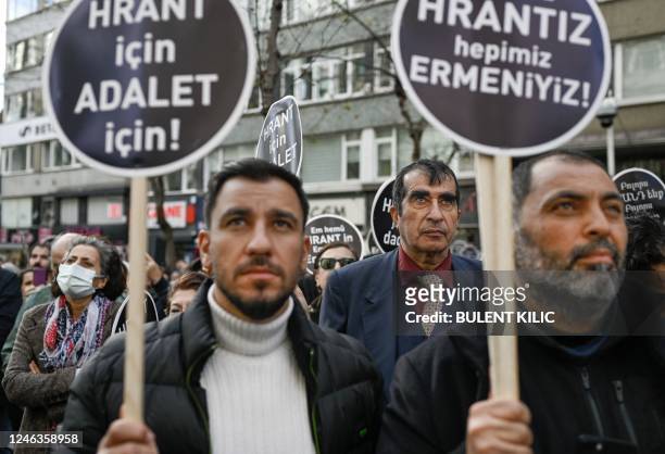 People hold placards, some of them reading "Justice for Hrant, we are all Armenian" in front of the offices of Armenian weekly newspaper Agos in...