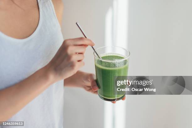 young woman drinking green juice for cleanse diet - cure détox photos et images de collection