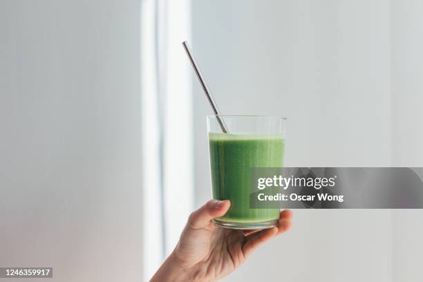 young woman drinking green juice for cleanse diet - metal straw stock pictures, royalty-free photos & images