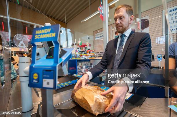 Dpatop - 19 January 2023, Saxony, Görlitz: Michael Kretschmer , Prime Minister of Saxony, stands at the checkout in a Lidl store. The sales collected...