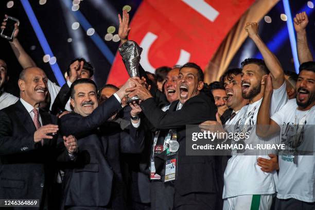 Iraq's Prime Minister Mohamed Shia al-Sudani celebrates with the national football team's players as they lift the trophy after winning the 25th...