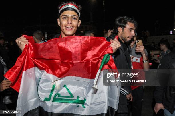 Football fans holds up the flag of Iraq while celebrating the Iraqi national team's victory against Oman to win the 25th Arabian Gulf Cup...