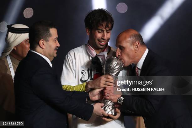 Iraq's football federation president Adnan Derjal kisses the Arabian Gulf Cup trophy presented by Prime Minister Mohammed Shia al-Sudani and team...