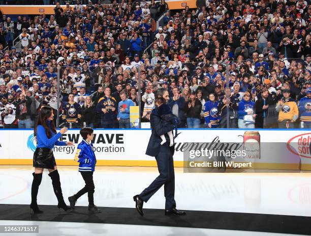 Former Buffalo Sabres goaltender Ryan Miller waves to the crowd as he walks with his family during his jersey retirement ceremony prior to the NHL...