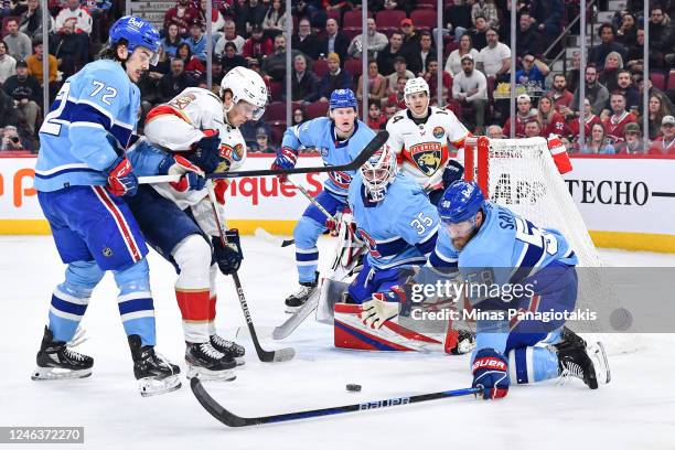 David Savard of the Montreal Canadiens gets down to block the puck while teammate Arber Xhekaj defends against Eetu Luostarinen of the Florida...