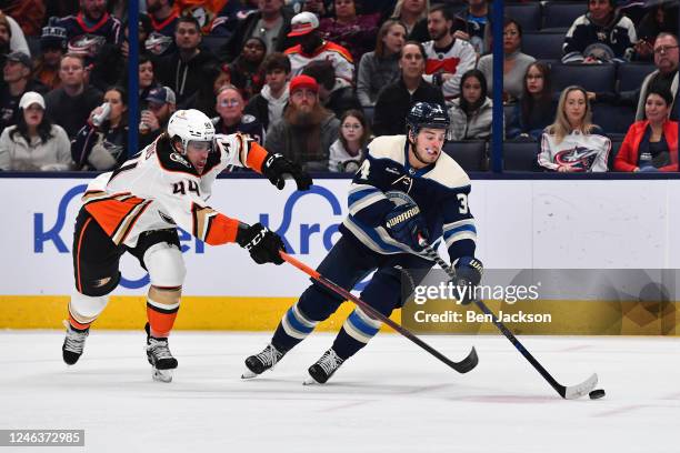 Cole Sillinger of the Columbus Blue Jackets skates with the puck as Max Comtois of the Anaheim Ducks defends during the second period of a game at...