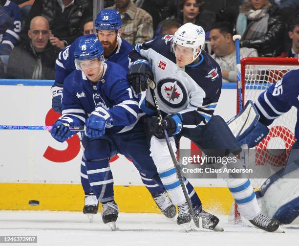 Saku Maenalanen of the Winnipeg Jets battles for the puck against Mitchell Marner of the Toronto Maple Leafs during an NHL game at Scotiabank Arena...