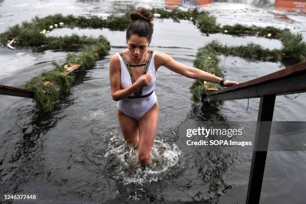 Woman crosses herself after emerging from near-freezing water in a river in Kyiv during the Epiphany. On January 19th, Ukrainian Orthodox Christians...