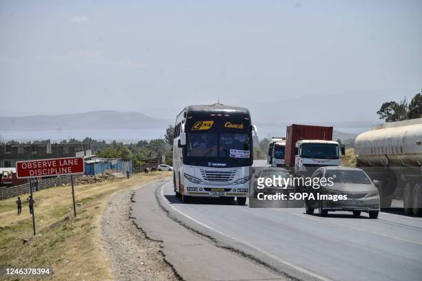 Vehicles drive past a road sign warning motorists to observe lane discipline placed at an area recently declared as a black spot 5km west of Nakuru...