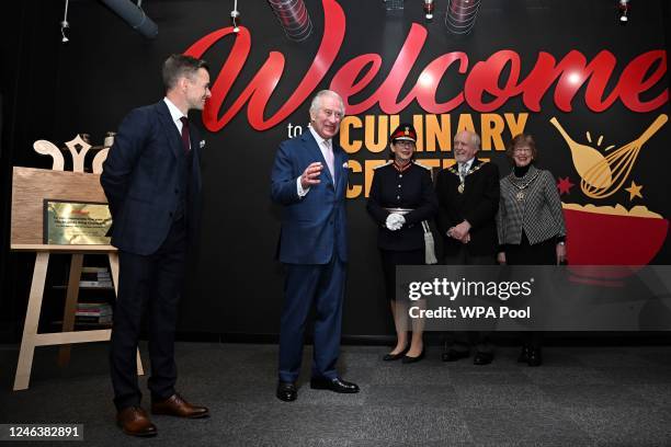 Britain's King Charles III unveils a plaque during a visit to the headquarters of cereal manufacturer Kellogg's in Manchester on January 20, 2023....