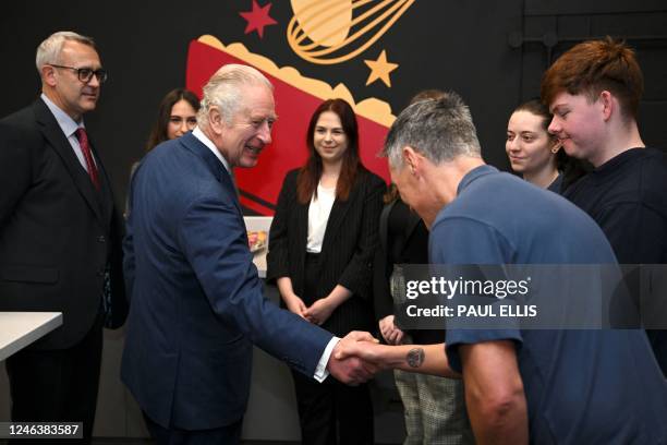 Britain's King Charles III meets with apprentices during a visit to the headquarters of cereal manufacturer Kellogg's marking its 100th anniversary...