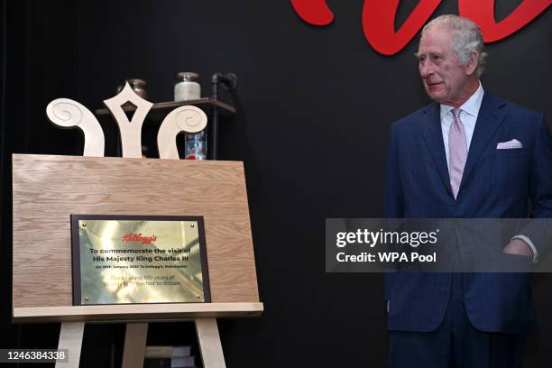 Britain's King Charles III unveils a plaque during a visit to the headquarters of cereal manufacturer Kellogg's marking its 100th anniversary in...