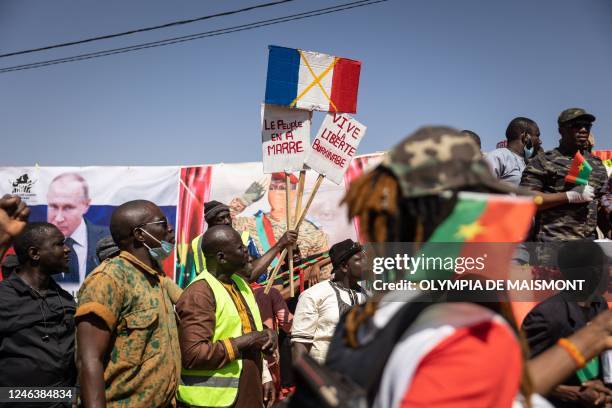 Demonstrator holds placards during a protest to support the Burkina Faso President Captain Ibrahim Traore and to demand the departure of France's...