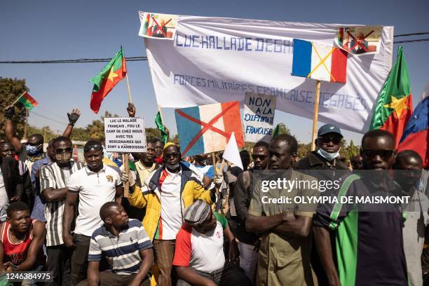 Demonstrators hold placards during a protest to support the Burkina Faso President Captain Ibrahim Traore and to demand the departure of France's...