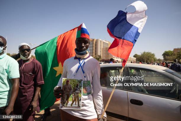 Man holds a Russian flag during a protest to support the Burkina Faso President Captain Ibrahim Traore and to demand the departure of France's...