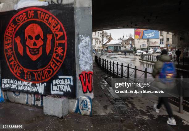 Pedestrian walks past a mural depicting the logo of the Russian mercenary 'Group Wagner' and a slogan in Russian by the informal pro-Russia...