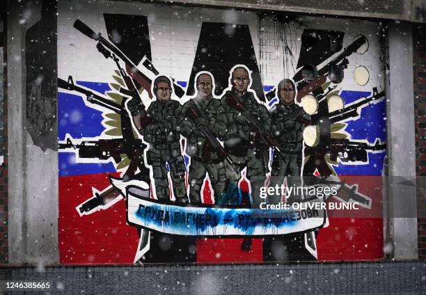 This picture shows a defaced mural to the glory of Russia's mercenary group Wagner reading "Wagner Group - Russian knights" on the side wall of an...