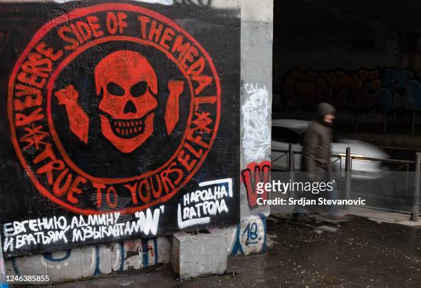 Pedestrian walks past a mural depicting the logo of the Russian mercenary 'Group Wagner' and a slogan in Russian by the informal pro-Russia...