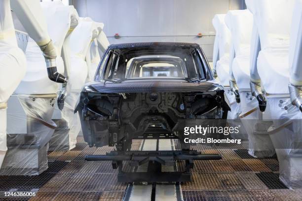 Robotic arms spray a Range Rover sports utility vehicle in the paint shop at Tata Motors Ltd.'s Jaguar Land Rover vehicle manufacturing plant in...