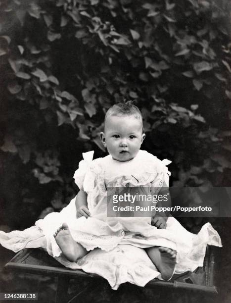 Small child with bare feet wearing a Christening gown, circa 1920.