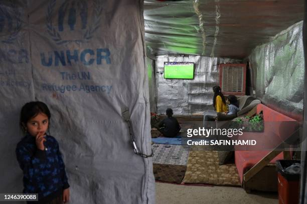 Displaced Iraqi children from the Yazidi community watch a football match on televison inside a tent at a camp for internally displaced persons in...
