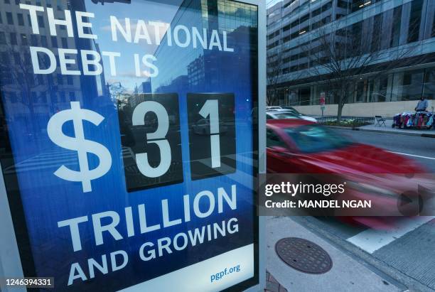 Sign at a bus shelter shows the national debt in Washington, DC on January 20, 2023. - The US Treasury said it began taking measures Thursday to...
