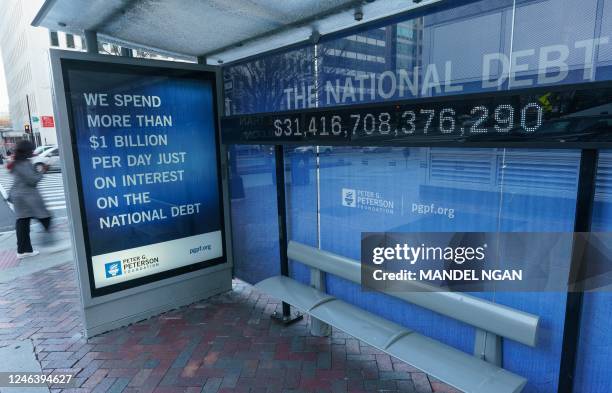 Sign at a bus shelter shows the national debt in Washington, DC on January 20, 2023. - The US Treasury said it began taking measures Thursday to...