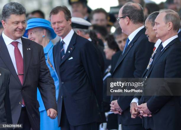 In this file photo Ukraine's President-elect Petro Poroshenko walks past Russian President Vladimir Putin as they attend commemoration ceremonies...