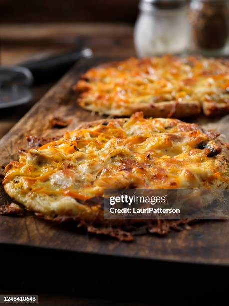 small 8" thin crust roast chicken pizza with alfredo sauce, mushrooms and red peppers on pita bread - tortilla stock pictures, royalty-free photos & images