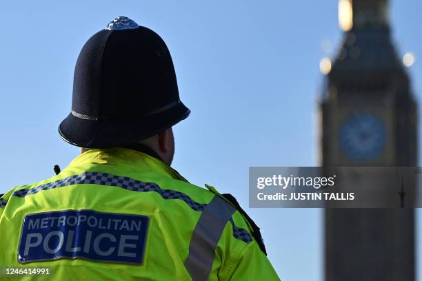 Metropolitan Police officer walks beside a protest march against the Islamic revolutionary Guard Corps near Big Ben and the Houses of Parliament, in...