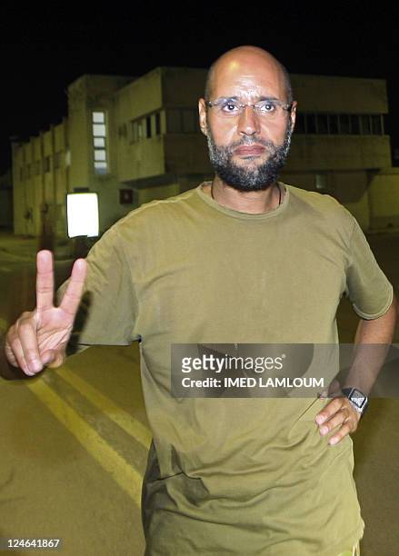 Saif al-Islam Kadhafi, son of Libyan leader Moamer Kadhafi, flashes the V-sign for victory as he appears in front of journalists at his father's...