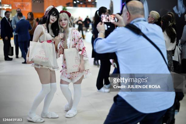 Man takes models in picture during the International lingerie fair in Paris, on January 21, 2023.