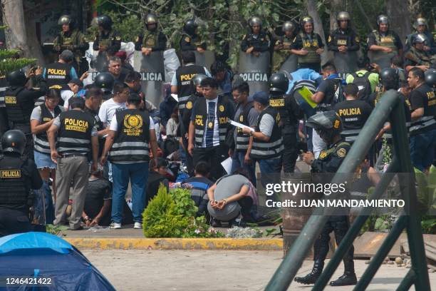 Alleged protesters wait to be transferred after being arrested by the police at the campus of the University of San Marcos in Lima on January 21,...