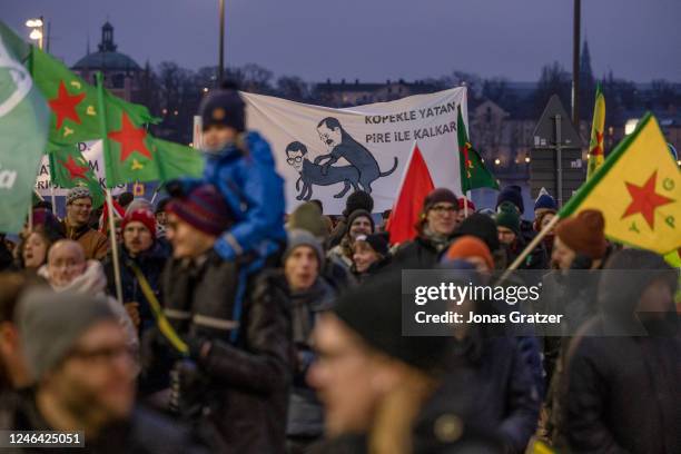 Protesters carry a poster depicting a caricature of Swedish Prime Minister Ulf Kristersson and Turkish President Recep Tayyip Erdogan as two dogs...