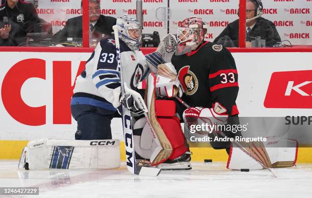 Cam Talbot of the Ottawa Senators and David Rittich of the Winnipeg Jets converse at the redline during warm-up prior to a game at Canadian Tire...
