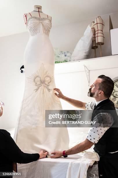 French fashion designer Julien Fournie works on an embroidered dress at his studio, ahead of the Spring-Summer 2023 Haute Couture Fashion Week, in...